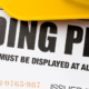 Stack of blueprints with Building Permit text across the top with yellow hard hat