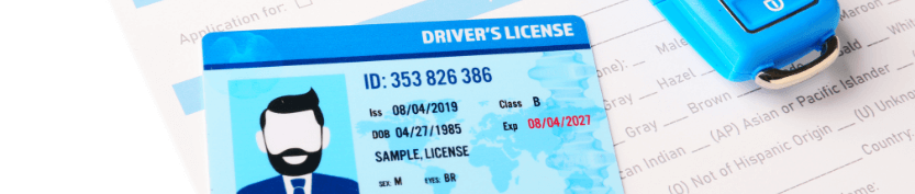 Drivers license card with placeholder information on it resting on top of a paper application form along with a key FOB.