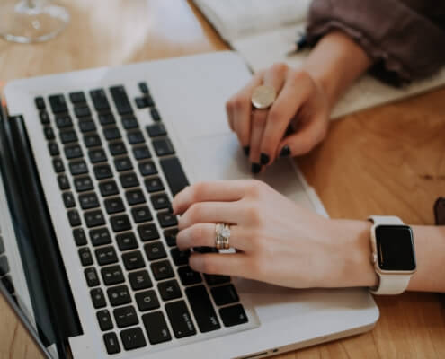 Two hands resting on a laptop computer