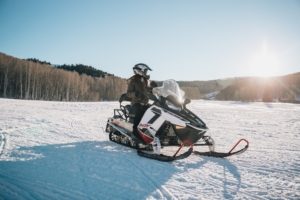 A person riding a snowmobile in the backcountry
