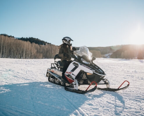 A person riding a snowmobile in the backcountry