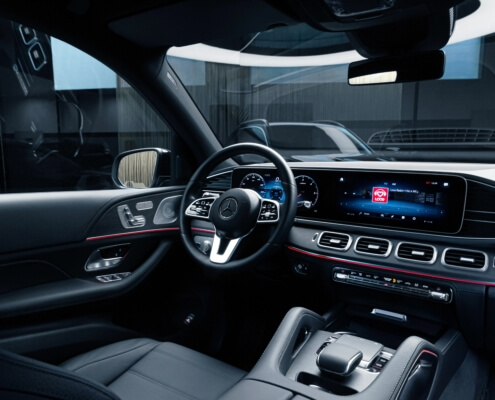 The inside of a vehicle focused on the driver's seat, wheel and dashboard