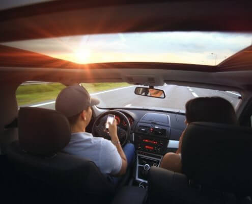 A view from the backseat of a driver using a cell phone & driving distracted