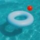 A closeup of water in a swimming pool with a flotation device & a pool toy
