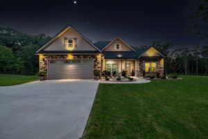 Night image of a home including it's driveway and lawn