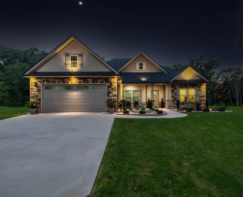 Night image of a home including it's driveway and lawn