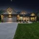Night image of a home including it's driveway and lawn