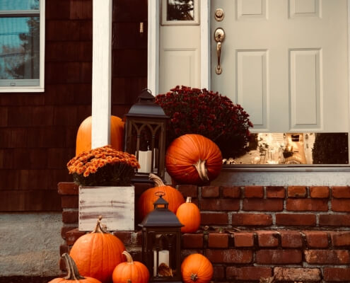 pumpkins line the doorstep of a home