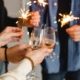 A closeup of wine glasses and New Year's Eve sparklers