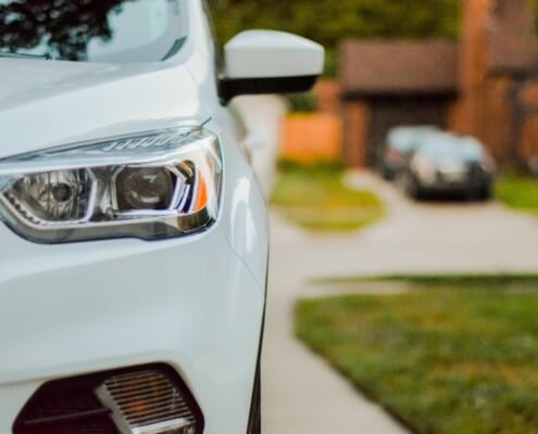 Close up of a vehicle's headlight parked in a driveway