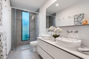 A photo of a full size bathroom including a counter top, toilet and shower.