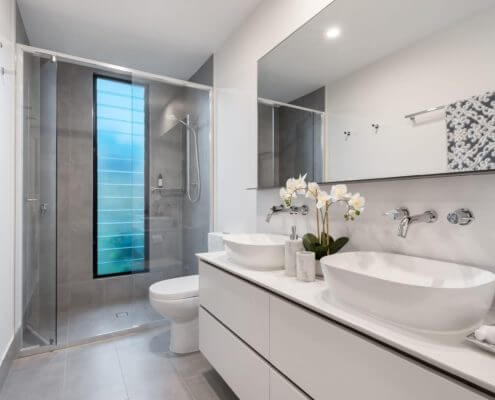 A photo of a full size bathroom including a counter top, toilet and shower.